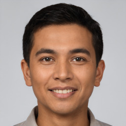 Joyful latino young-adult male with short  brown hair and brown eyes