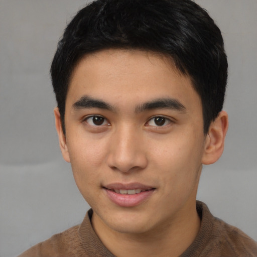 Joyful asian young-adult male with short  brown hair and brown eyes