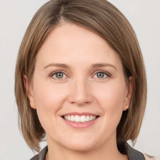 Joyful white young-adult female with medium  brown hair and grey eyes