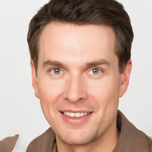 Joyful white adult male with short  brown hair and grey eyes