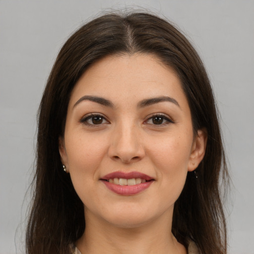 Joyful latino young-adult female with long  brown hair and brown eyes