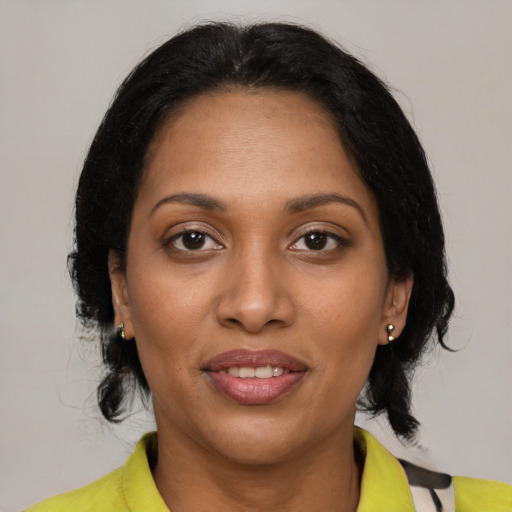 Joyful black adult female with medium  brown hair and brown eyes