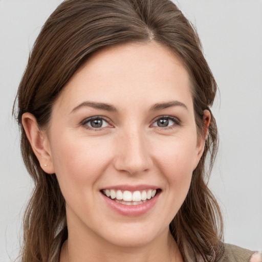 Joyful white young-adult female with long  brown hair and grey eyes