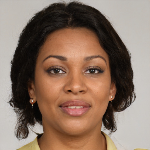Joyful black young-adult female with medium  brown hair and brown eyes