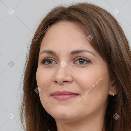 Joyful white adult female with long  brown hair and brown eyes