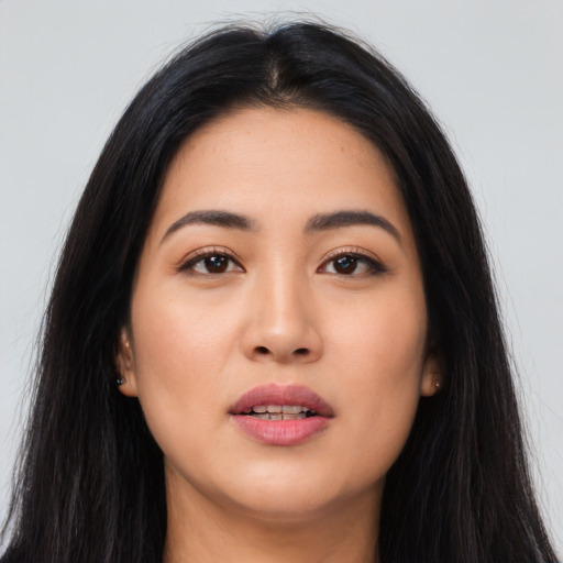 Joyful asian young-adult female with long  brown hair and brown eyes