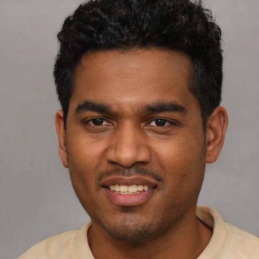 Joyful black young-adult male with short  black hair and brown eyes
