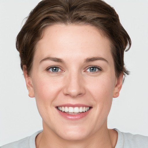 Joyful white young-adult female with short  brown hair and grey eyes