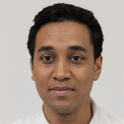 Joyful latino adult male with short  black hair and brown eyes