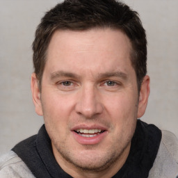 Joyful white adult male with short  brown hair and brown eyes