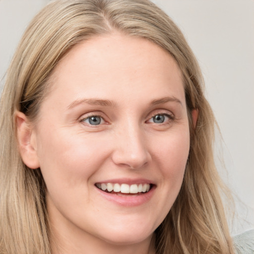 Joyful white young-adult female with long  brown hair and blue eyes