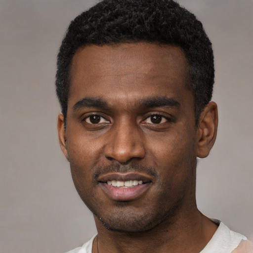 Joyful black young-adult male with short  black hair and brown eyes