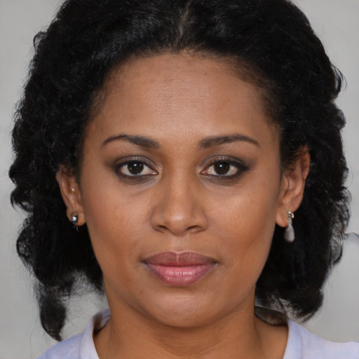 Joyful black adult female with medium  brown hair and brown eyes