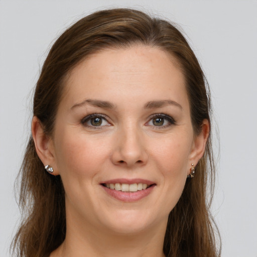 Joyful white young-adult female with long  brown hair and grey eyes