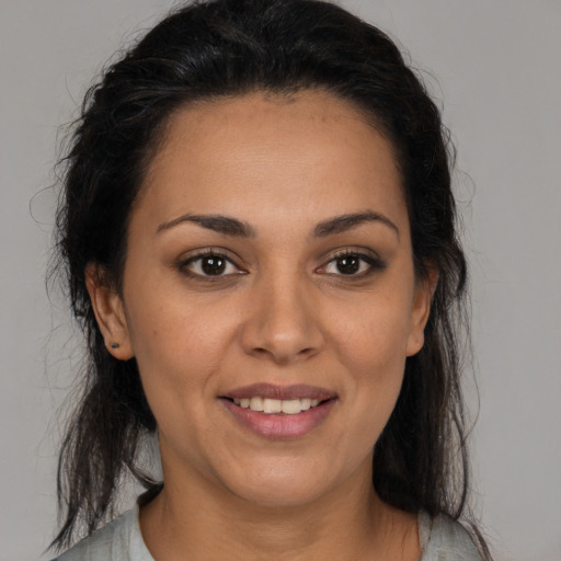 Joyful latino young-adult female with long  brown hair and brown eyes
