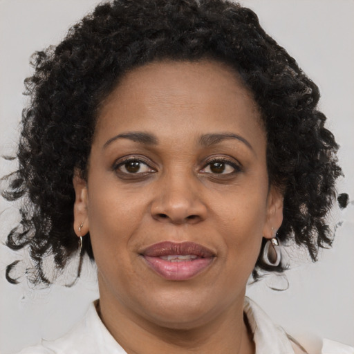 Joyful black adult female with medium  brown hair and brown eyes