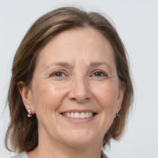 Joyful white adult female with medium  brown hair and grey eyes