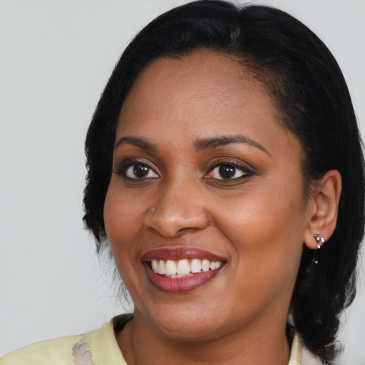 Joyful black young-adult female with medium  black hair and brown eyes