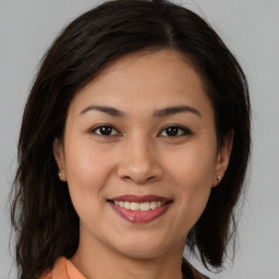 Joyful latino young-adult female with medium  brown hair and brown eyes