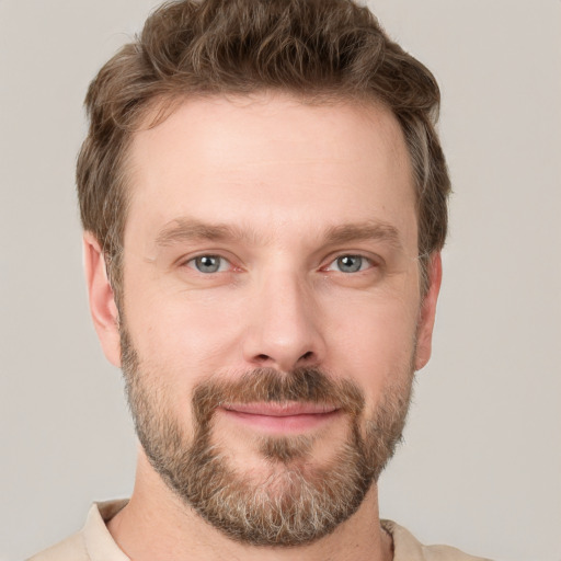 Joyful white young-adult male with short  brown hair and grey eyes