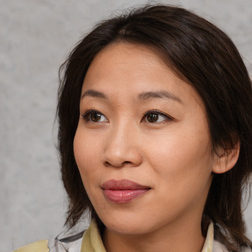Joyful asian young-adult female with medium  brown hair and brown eyes