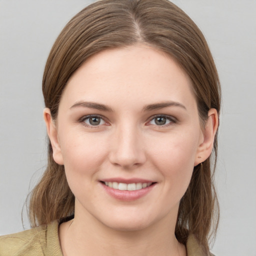 Joyful white young-adult female with medium  brown hair and grey eyes