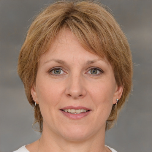 Joyful white adult female with medium  brown hair and grey eyes