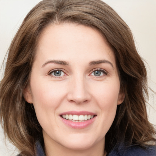 Joyful white young-adult female with medium  brown hair and blue eyes