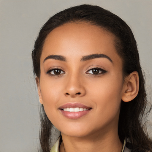 Joyful latino young-adult female with long  black hair and brown eyes