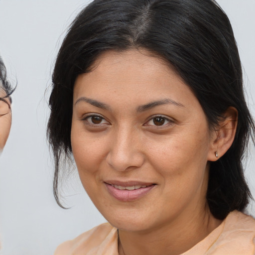 Joyful latino adult female with medium  brown hair and brown eyes