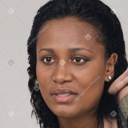 Joyful black young-adult female with long  black hair and brown eyes