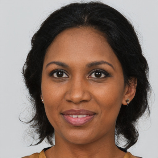 Joyful black adult female with medium  brown hair and brown eyes