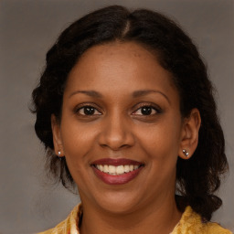 Joyful black young-adult female with long  brown hair and brown eyes