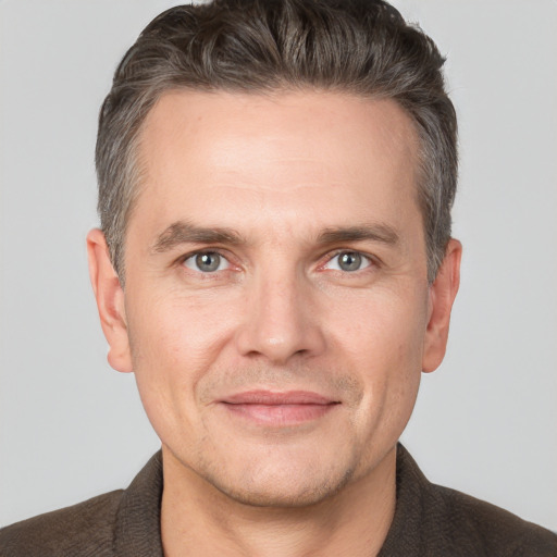 Joyful white adult male with short  brown hair and brown eyes