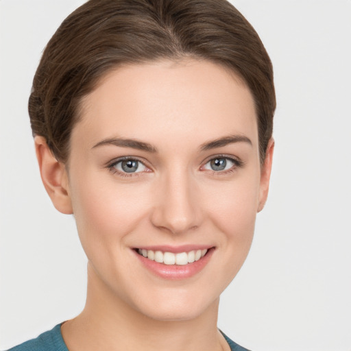 Joyful white young-adult female with short  brown hair and grey eyes