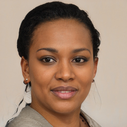 Joyful black young-adult female with short  black hair and brown eyes