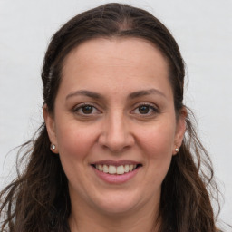 Joyful white adult female with long  brown hair and brown eyes