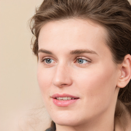 Joyful white young-adult female with long  brown hair and blue eyes