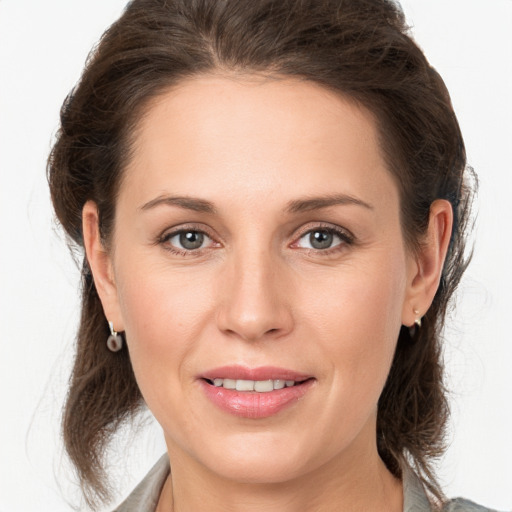 Joyful white young-adult female with medium  brown hair and grey eyes