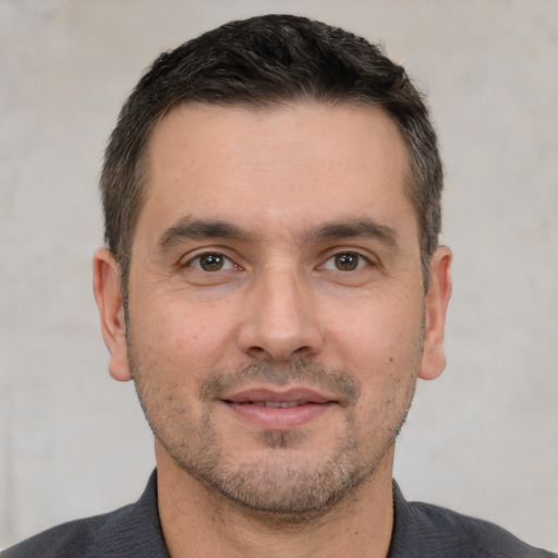 Joyful white young-adult male with short  black hair and brown eyes