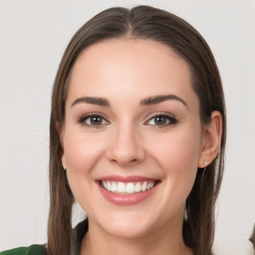 Joyful white young-adult female with long  brown hair and green eyes