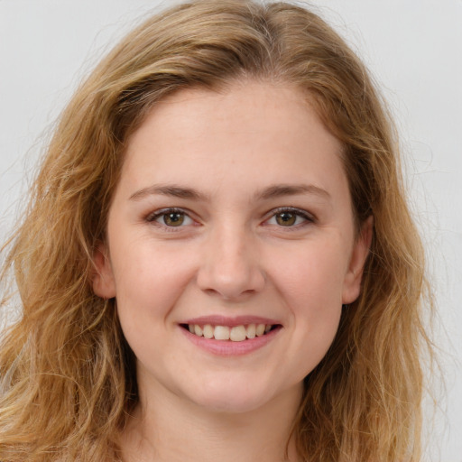 Joyful white young-adult female with long  brown hair and brown eyes