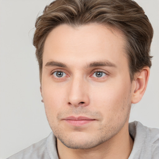 Joyful white young-adult male with short  brown hair and grey eyes