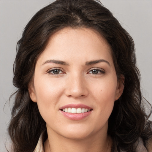 Joyful white young-adult female with long  brown hair and brown eyes