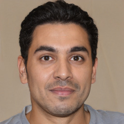 Joyful white young-adult male with short  black hair and brown eyes