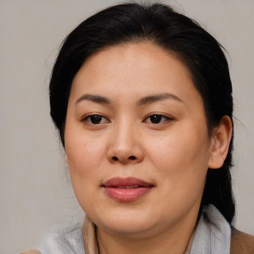 Joyful asian adult female with medium  brown hair and brown eyes