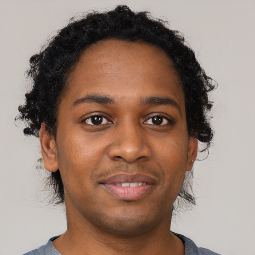 Joyful black young-adult male with short  brown hair and brown eyes