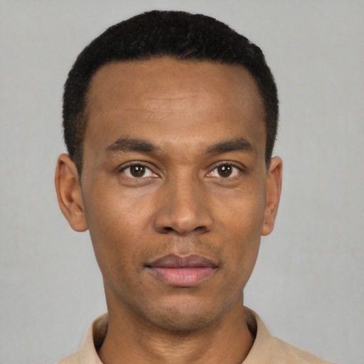 Joyful black young-adult male with short  black hair and brown eyes