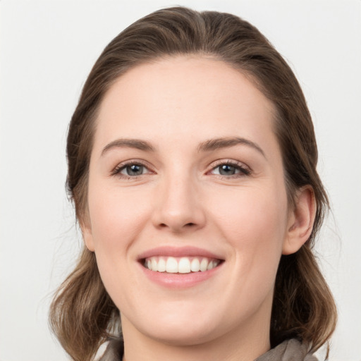 Joyful white young-adult female with medium  brown hair and grey eyes