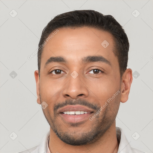 Joyful latino young-adult male with short  black hair and brown eyes